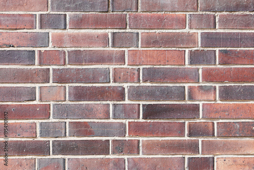 Red brick wall texture background. Masonry wall with horizontal brick pattern. Exterior building facade with weathered bricks. Construction material surface with detailed structure.