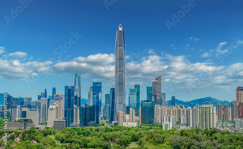Stunning cityscape of Shenzhen's Futian Central Business District with modern skyscrapers, lush green parks, and vibrant urban architecture under a clear blue sky.