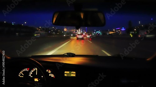 Car driving on a motorway at high speeds, overtaking other cars. A top-mounted camera captures what is in front of the car. Real time, night, point of view. POV.