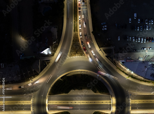 Foto Drone aerial of cars move in different directions at a roundabout in a city during the night