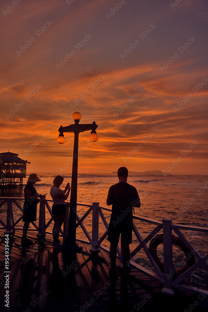 Fototapeta premium a family takes in the breathtaking views from the iconic pier of La Rosa Nautica in Miraflores, Lima. This striking capture highlights why the Costa Verde is a top destination for retired travelers 