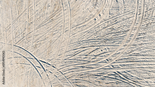 Aerial view tire tracks on sandy beach, Tire tracks on the sand  surface texture background, Tire tracks curve across the soft sand, Wheel tire track on sand texture and background.