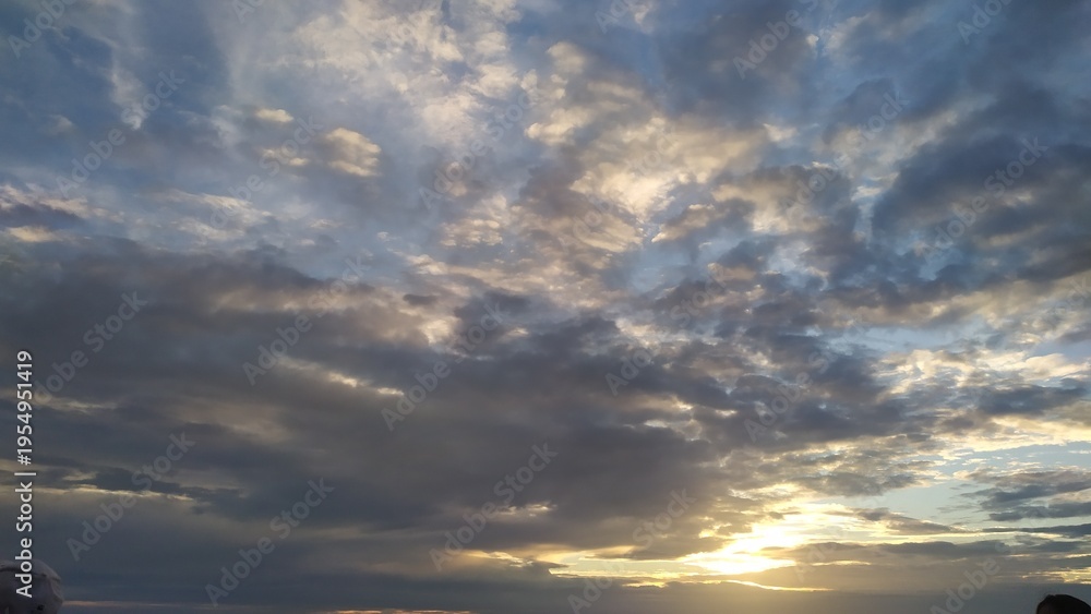 Obraz premium Blue sky and fluffy clouds. Beautiful cloudscape background. Sunlight on the clouds. The image captures a dramatic and peaceful moment of natural beauty, suitable for various design projects, backgrou