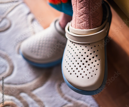 Foto Close-up of adult feet wearing comfortable rubber clog slippers indoors