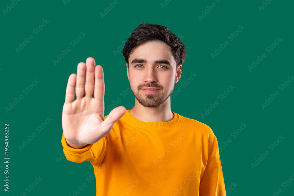 Fototapeta premium Portrait Of Serious Man In yellow Outfit Showing Rejecting Gesture, Stop Palm