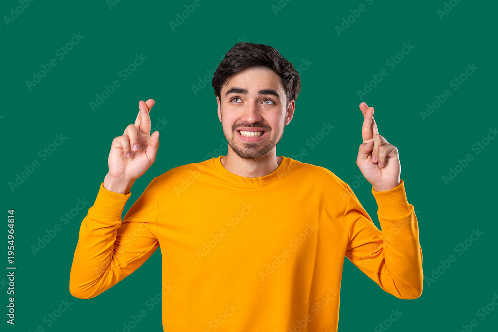 Fototapeta premium Handsome Man Crossing Fingers. Praying With Hopeful Expression, Silently Prays