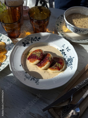 Fotografie Cottage Cheese Pancakes with Jam, Ground Pistachios and Creamy Sauce