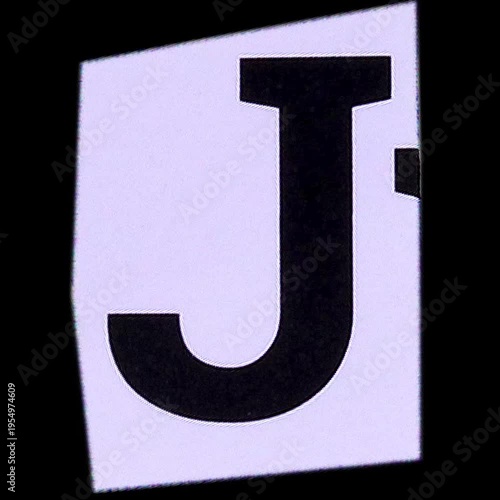 A close-up shot of a white letter 'N' on a black background, possibly a sticker or a cutout.