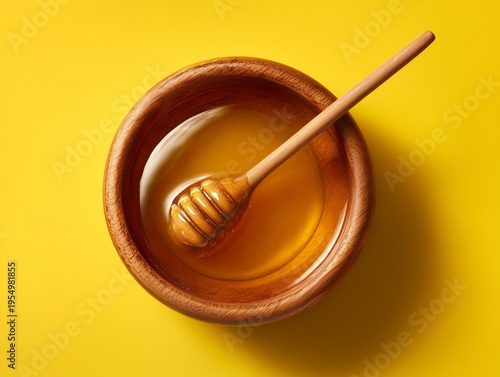 Honey in a Wooden Bowl With a Dipper on a Bright Yellow Background for Food P...