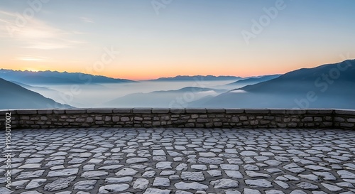 Stone terrace overlooking misty mountain valley at sunrise