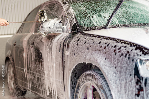 Photos A car is being thoroughly cleaned with soap and water at a designated washing st