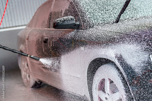 Billede på lærred During the daytime hours, a car washing facility applies foam to the surface of