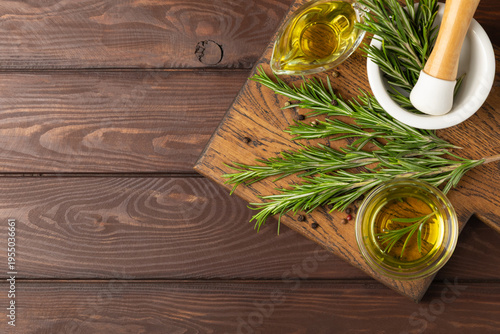 Culinary rosemary oil in a glass bottle with green rosemary sprigs, aromatic oil for cooking. Homemade rosemary oil, natural seasoning for cooking. Organic spiced oil. Herbs. Aromatherapy. Healthy