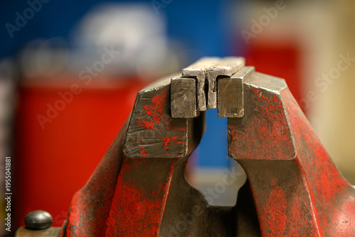 Fotografie An aluminum insert in a red workshop vise.