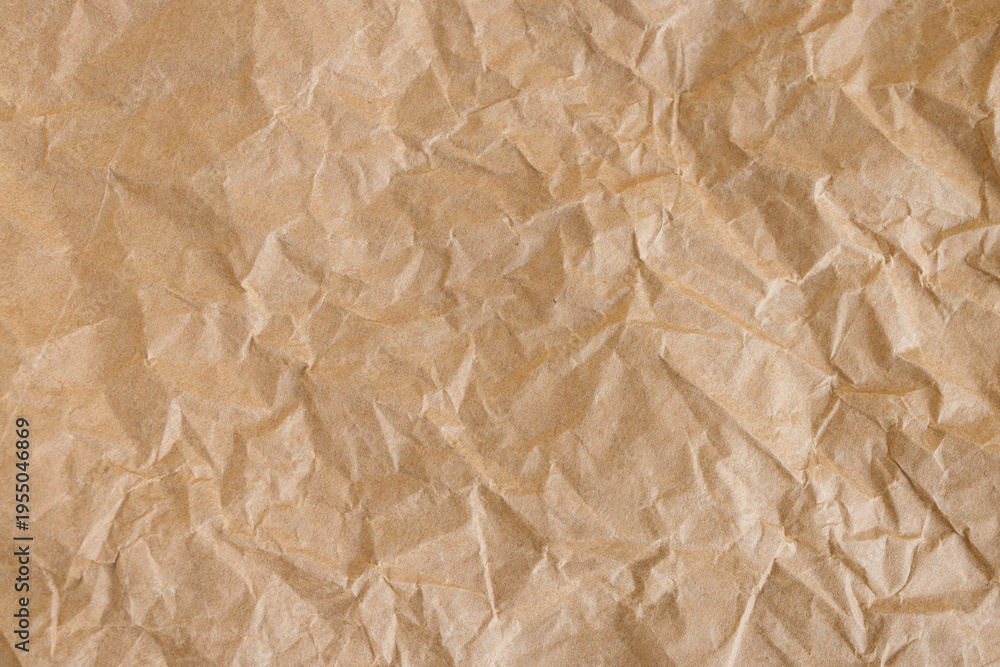 Obraz premium Crumpled Brown Kraft Paper Texture Background,Close-up top view of wrinkled and crumpled brown kraft paper texture. Abstract background of rough recycled paper surface with organic creases and folds, 
