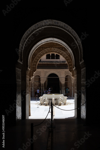 View through ornate arch to Fountain of the Lions in Alhambra, Granada, Spain