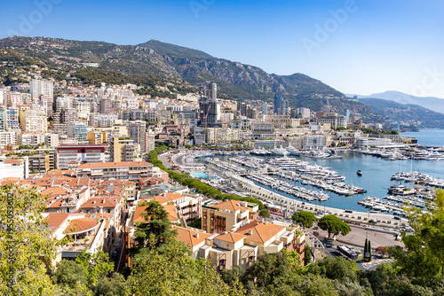 Luxury yachts and harbor in Monaco with city skyline and mountains