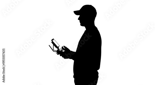Silhouette of a Man Operating a Drone Remote Controller