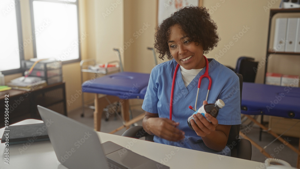 Fototapeta premium Young african american woman doctor holds medicine bottle beside laptop during online clinic consultation in building; compassion trust.