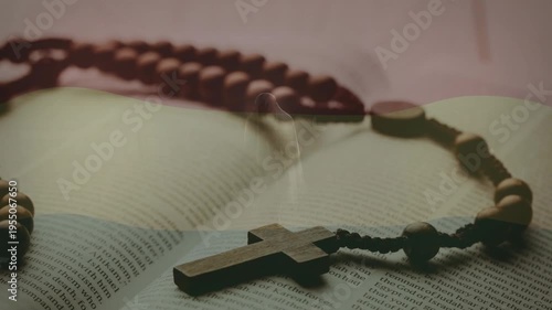 Wooden rosary resting on open book, subtle lighting shifting focus, evoking calm religious mood