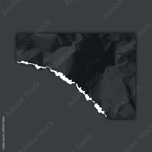 A torn, angular piece of black paper, wrinkled, with a jagged white edge on a dark background.