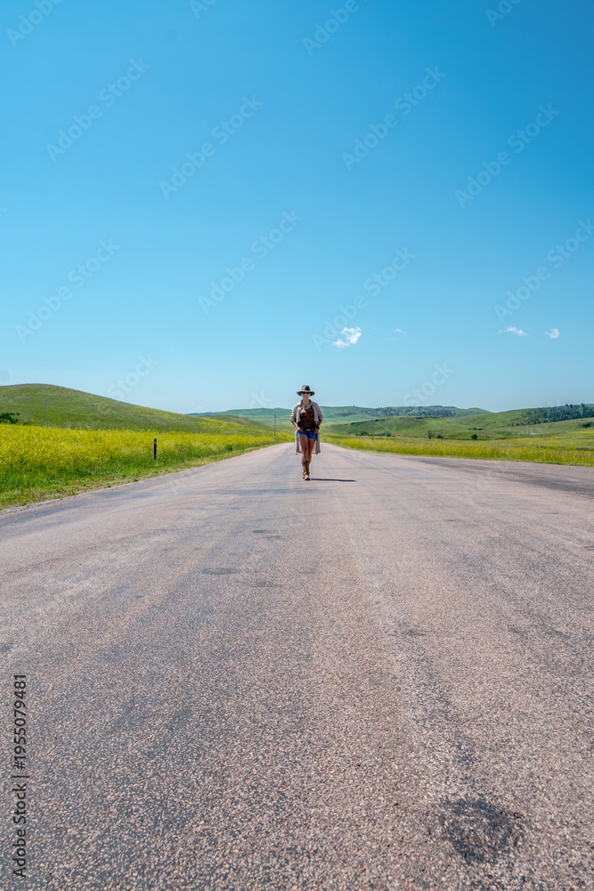 Obraz premium Lone cyclist rides down a sunlit road