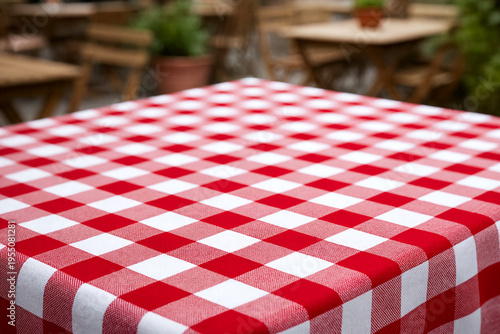 Empty table with a red and white checkered tablecloth in an outdoor restaurant patio