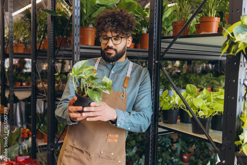 Florist caring for a potted plant in a modern flower shop, focusing on sustainable entrepreneurship and plant care