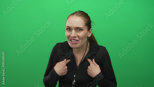 Photos Young caucasian woman trainer points finger to chest with whistle around neck in studio; surprise innocence