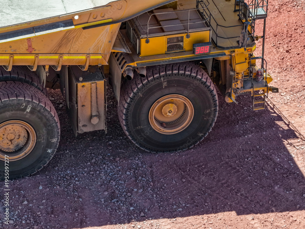 Fototapeta premium Aerial view of a CAEX mining truck traveling along a mining road towards the bottom of an open pit mine