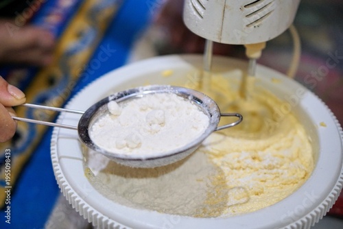 Wallpaper Mural Process of making cake batter using an electric mixer and flour sifter, representing baking activity in a home kitchen. Torontodigital.ca