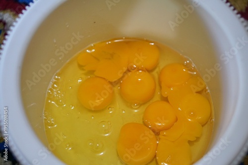 Wallpaper Mural Raw eggs in a bowl with intact yolks, representing basic cooking ingredients and food preparation in the kitchen. Torontodigital.ca