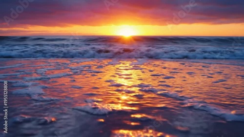 Stunning sunset over the ocean with waves crashing on the sandy beach reflecting golden sunlight