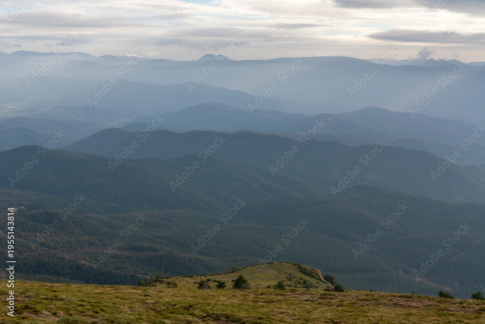 Fototapeta premium Atmospheric layered mountain ranges with soft light and haze near Jaca, Pyrenees, Spain. Natural scenic background.