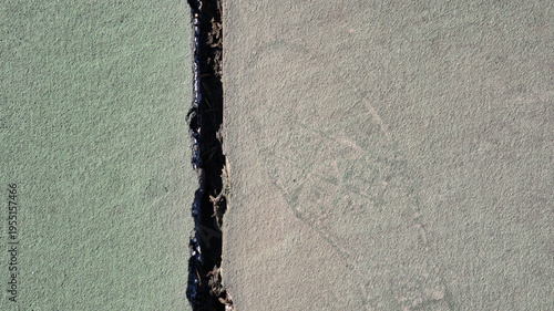 Foto A top-down view of a green synthetic sports court divided by a wide, jagged vertical crack