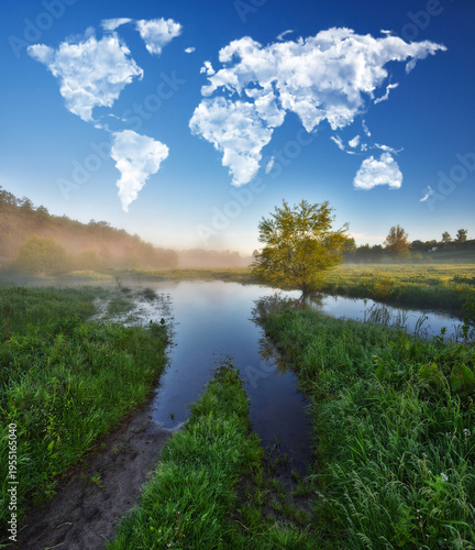 clouds in the form of a world map over a picturesque river. travel and landscape concept. spring meadow