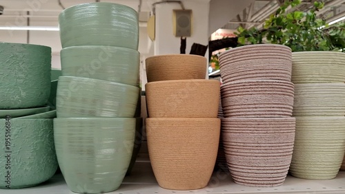 Close-up of various ceramic flower pots in pastel shades. Products for home gardening. Row of colorful stoneware planters with ribbed and smooth textures. Containers for indoor plants, modern interior