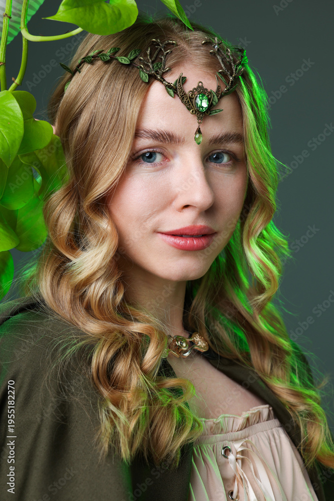 Obraz premium Beautiful elf girl and green leaves on grey background