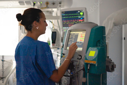 Nurse monitoring dialysis machine in hospital setting