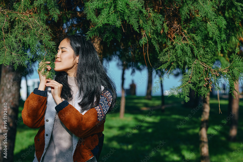 Fototapeta premium Nature, outdoors, greenery, leaves, fragrance, breeze, park, relaxation, serenity, woman exploring leaves in a sunlit park, capturing fragrance and breeze as she relaxes among trees, enjoying