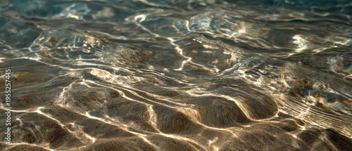 Sunlight reflections on clear shallow water surface creating abstract patterns.