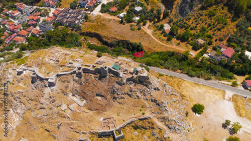 Wallpaper Mural Fethiye, Turkey. Aerial drone view of the medieval Fethiye Castle ruins on the hilltop with large Turkish flag, overlooking the city, marina and Mediterranean sea on a sunny day.. Aerial View Torontodigital.ca
