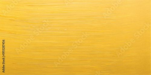 A vintage brushed gold metal texture with a rough grunge pattern on an antique yellow surface creates a weathered metallic backdrop for design