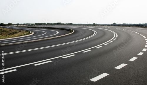 Empty asphalt highway curve road with white markings stretching into the horizon during a bright clear day photograph