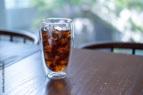 A glass of Cola on the table with bokeh background