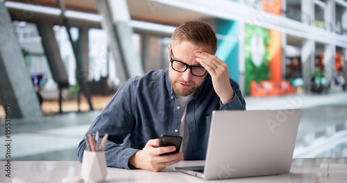 Cuadro en lienzo Man Worriedly Examines Smartphone For Payment Problems