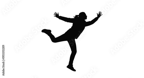 A woman joyfully leaps in the air captured as a silhouette