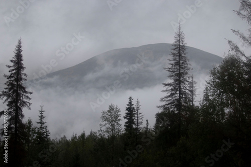 Φωτογραφία Small area of mountain through clouds and fog