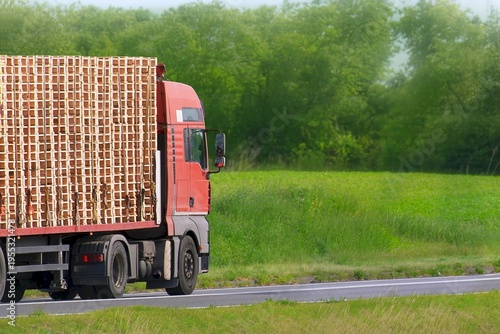 Obraz na plátne Flatbed truck transporting wooden pallets in countryside