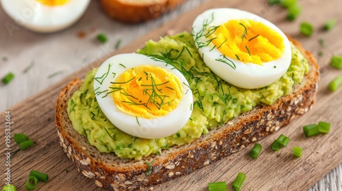 Toasted multigrain bread topped with mashed avocado, halved boiled eggs, and garnished with fresh dill and chopped green onions.